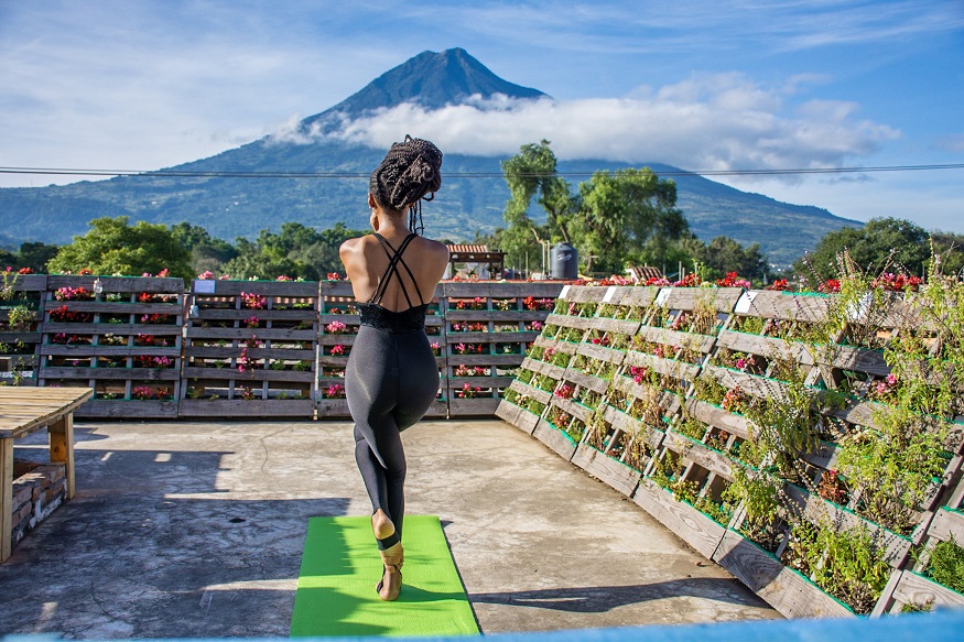 female hostel owners, woman doing yoga at The Purpose Hostel with mountain in the background