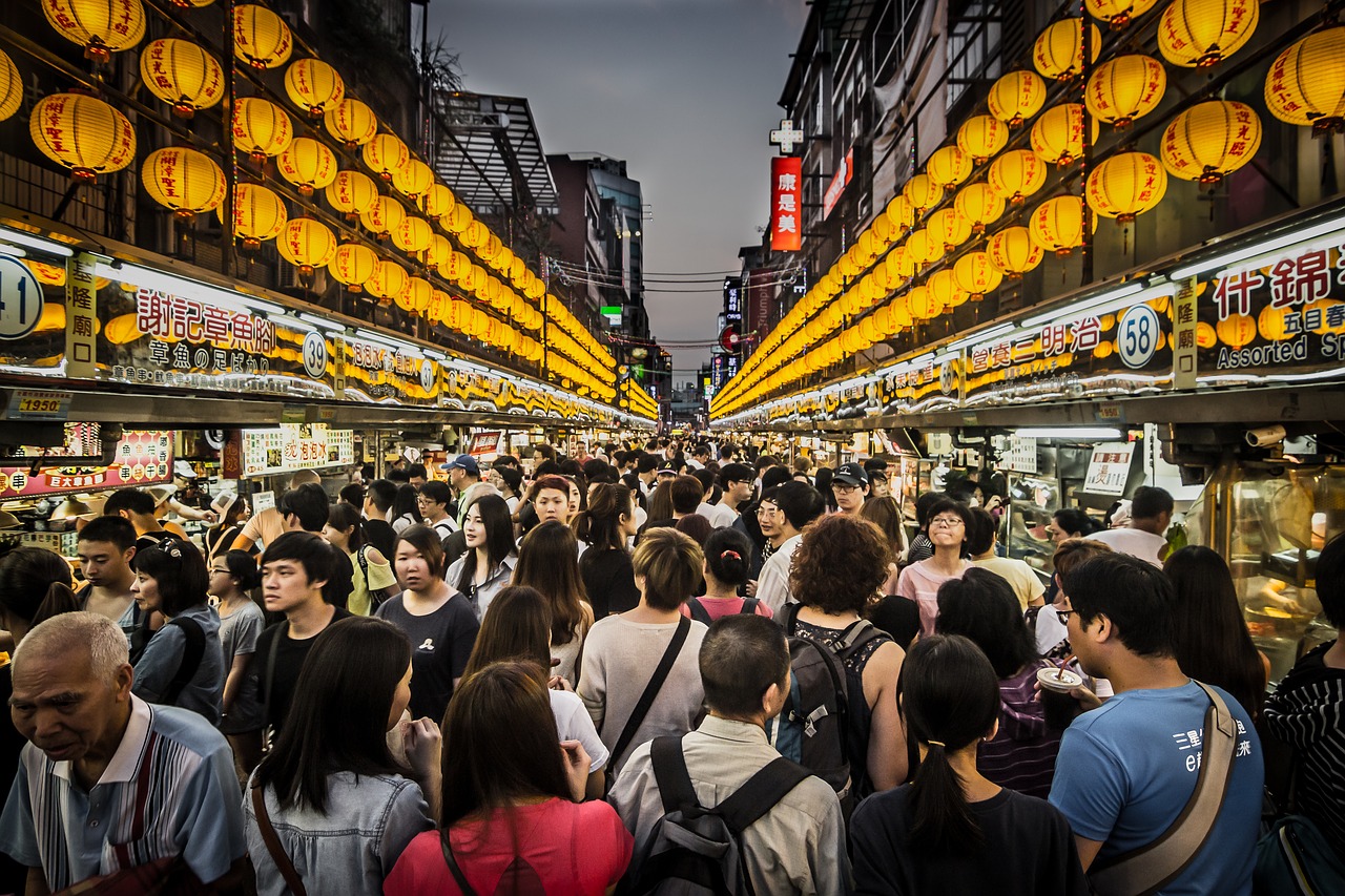 how to avoid overtourism, crowd of people walking down the street in asia